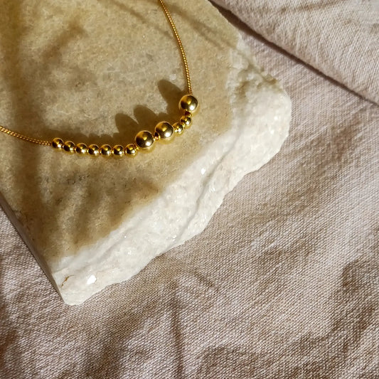 Kultainen Viesti-kaulakoru, jossa lukee morseaakkosilla kirjoitettuna Ihana.