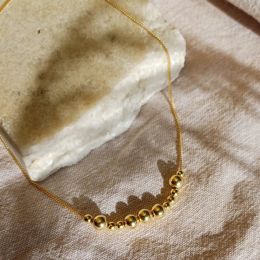 Kultainen Viesti-kaulakoru, jossa lukee morseaakkosilla kirjoitettuna englanninkielinen sana Love.