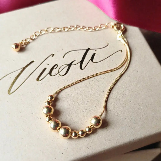 Kultainen Viesti-rannekoru, jossa lukee morseaakkosilla Upea.