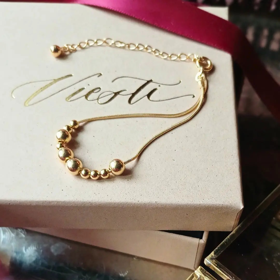 Kultainen Viesti-rannekoru, jossa lukee morseaakkosilla upea.