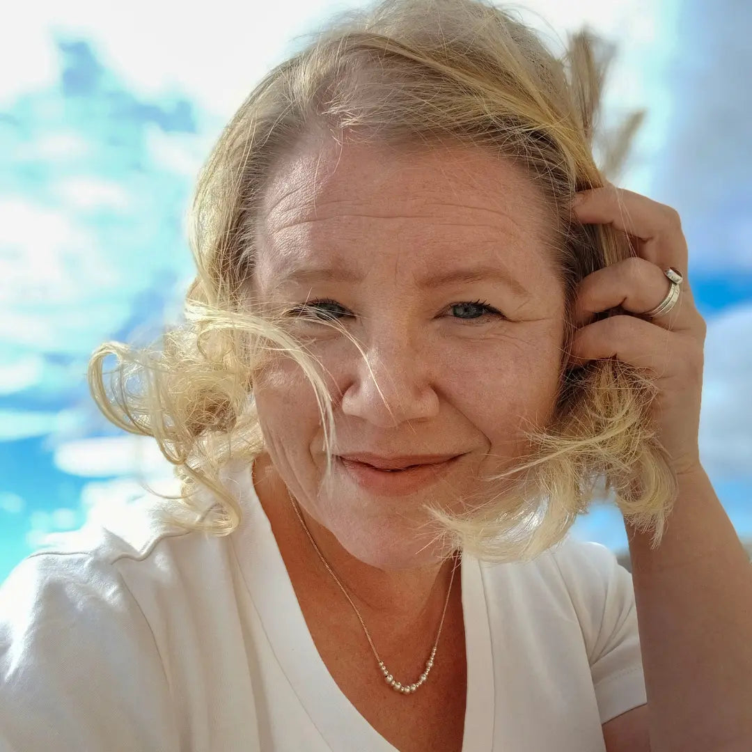 Vaalealla naisella on kaulassaan hopeinen Viesti-koru, jossa lukee morseaakkosilla Vapaus.