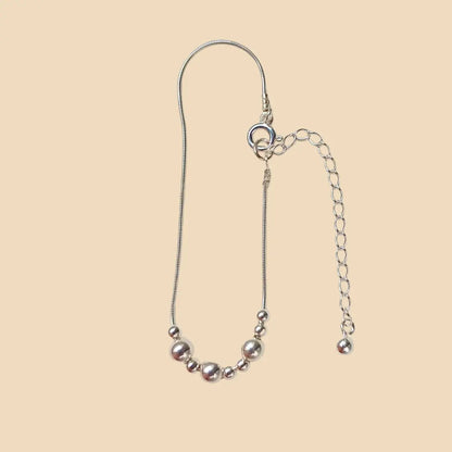 Hopeinen rannekoru. jossa lukee morseaakkosilla äiti