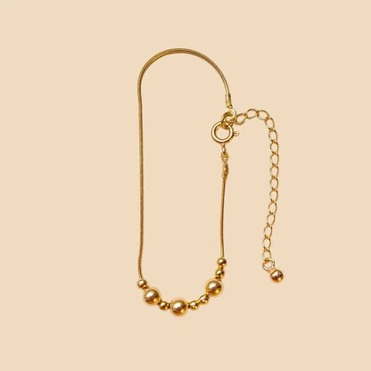 Kullattu hopeinen rannekoru, jossa lukee morseaakkosilla äiti.