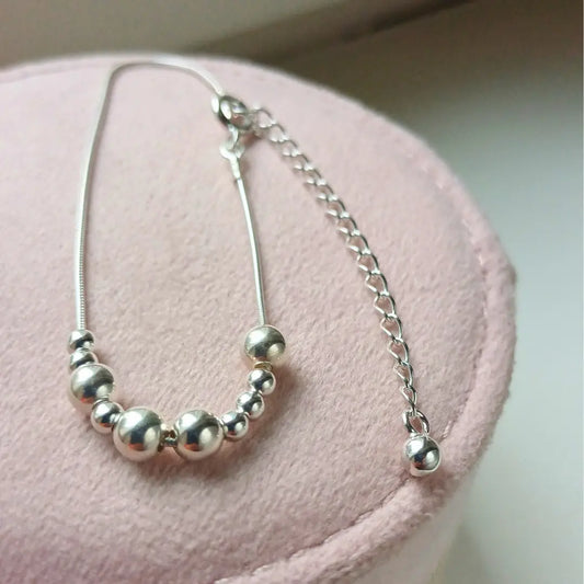 Hopeinen Viesti-rannekoru, jossa lukee morseaakkosilla Upea.