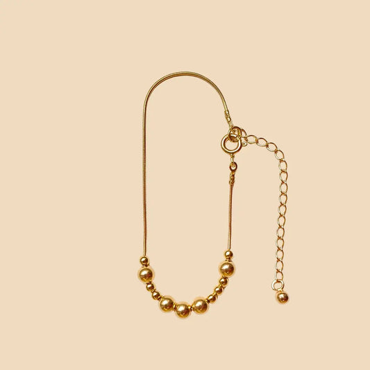 Hopeinen kullattu rannekoru, jossa lukee morseaakkosilla englanniksi love.