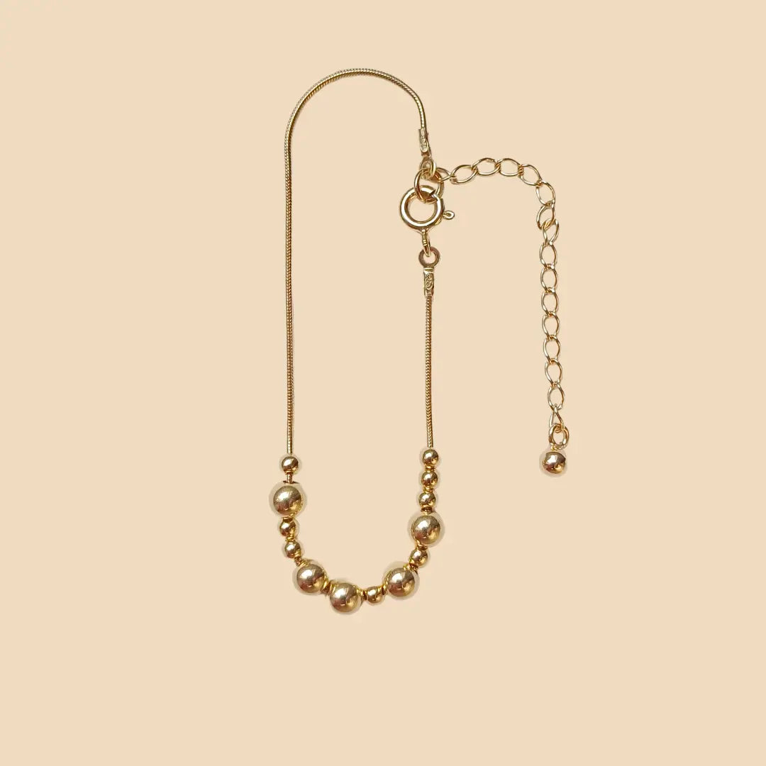 Kullattu hopeinen rannekoru, jossa lukee morseaakkosilla rakas.